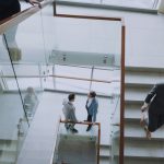 Aerial view of professionals conversing in a glass staircase in a modern office. — Are there different types of football bett