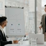 Professionals discussing a business chart in a modern office. — Discover the Best Instant Funding Prop Firms to Fast-Track Yo
