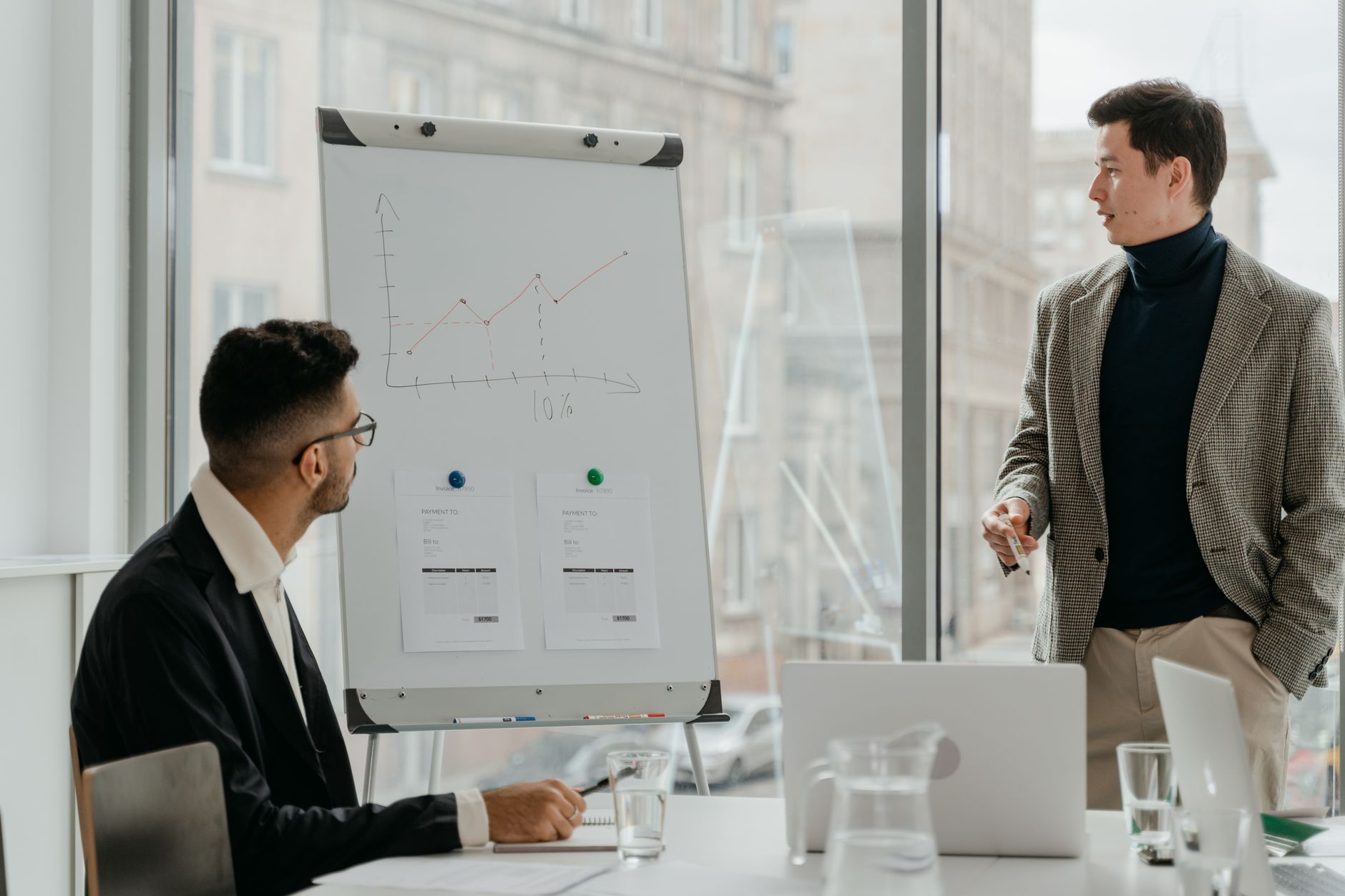 Professionals discussing a business chart in a modern office. — Discover the Best Instant Funding Prop Firms to Fast-Track Yo