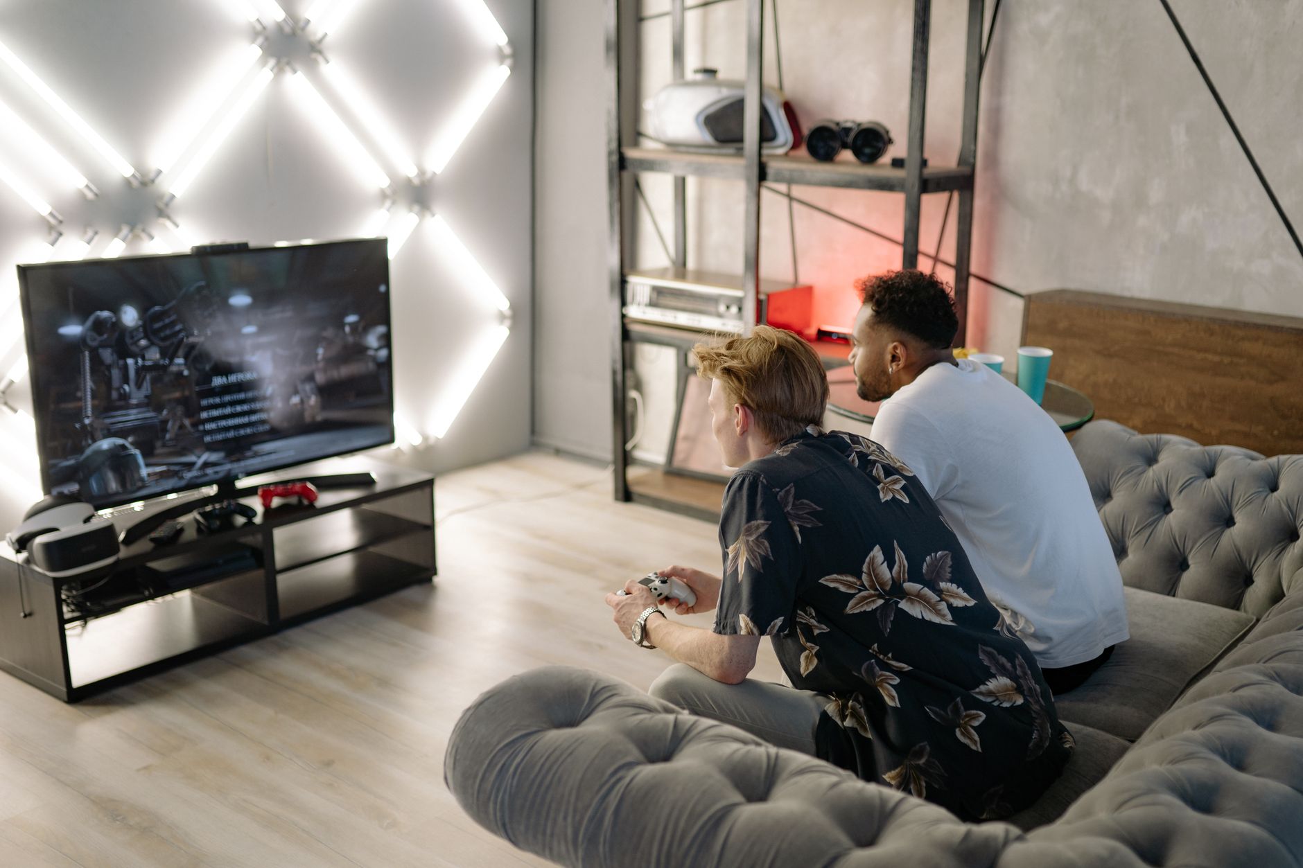 Two young men gaming together in a stylish modern living room with a large TV. — Enjoy Secure, Fast and Easy Payments WithLum