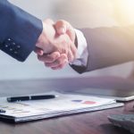 Professional handshake agreement over business charts in an office setting. — Get the High-End Look with Knock-Off Designer B