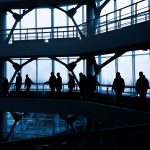 Silhouettes of people walking in a modern architectural building with large windows. — Lake Front Homes For Sale In Clear Lak