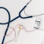 Flat lay of medical tools including stethoscope and measuring tape on a white background. — Making a Information Attribute St