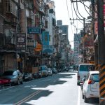 A busy street lined with cars and various colorful business signs on a sunny day. — Discover the Thrill of High-Speed