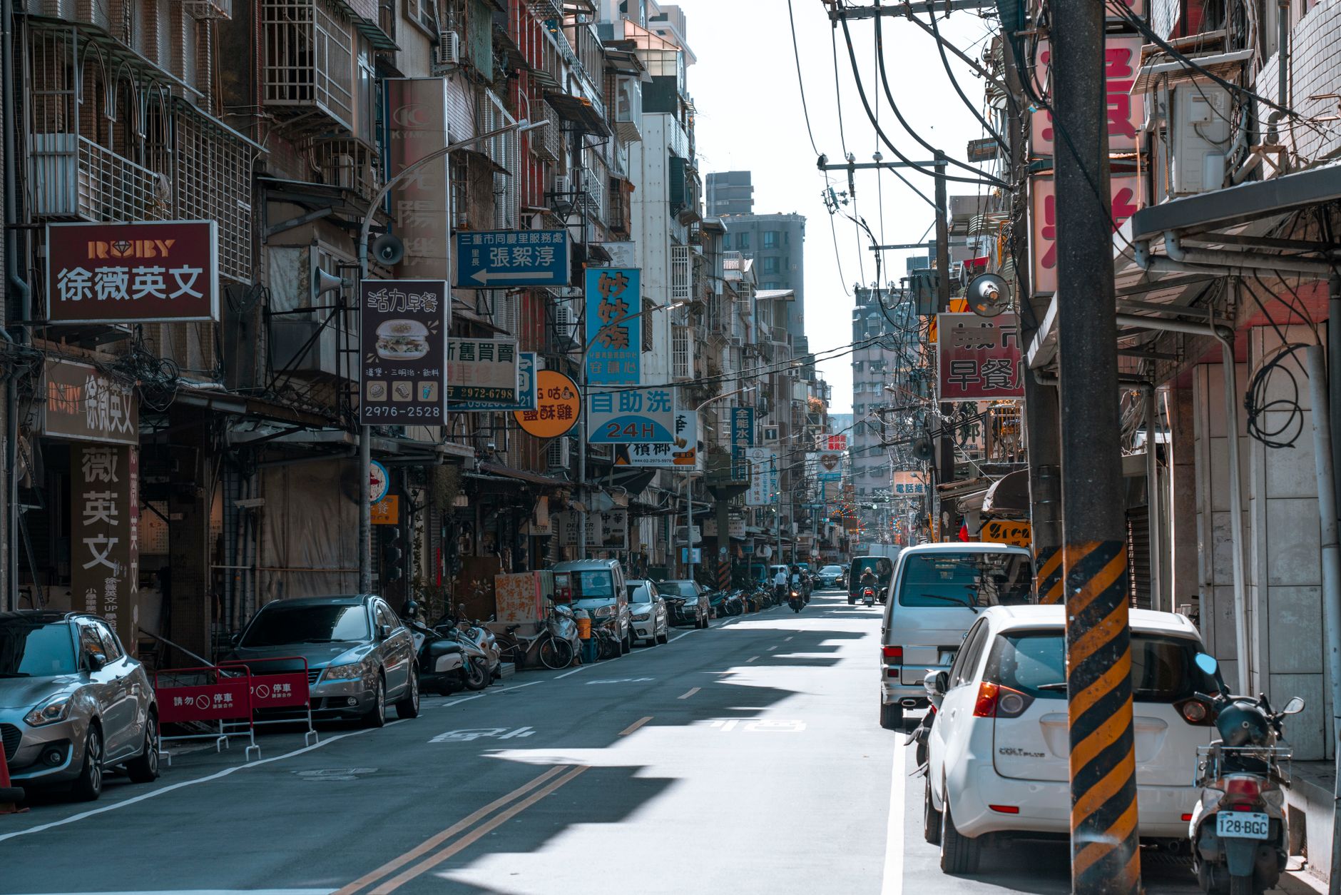 A busy street lined with cars and various colorful business signs on a sunny day. — Discover the Thrill of High-Speed
