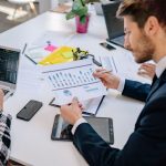 Business team reviewing graphs and data in an office setting. — How to Use a Ledger Nano S to Manage Digital Assets