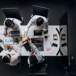 High angle view of colleagues collaborating around a conference table in a modern office setting. — The ABCs of Working with