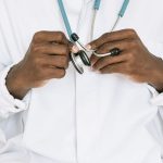 A professional doctor holding a stethoscope, focusing on hands and medical tools. — The Insanity Chronicles - Episode 50