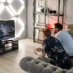 Two young men gaming together in a stylish modern living room with a large TV. — Try Bonuses at the Casino to Boost Your Thri
