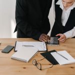 Two professionals collaborating over charts and tablet in a modern office setting. — Versatile Protection: Nitrile Gloves for