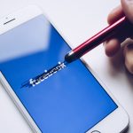 Close-up of a smartphone with a stylus crossing out text on its screen. — White Label Facebook Ads: Driving Agency Growth and