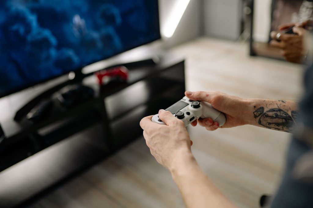 Person playing video games using a game controller indoors on a modern TV setup. — Why Eat and Run Verification Prevents Play