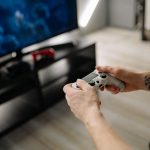 Person playing video games using a game controller indoors on a modern TV setup. — Why Eat and Run Verification Prevents Play
